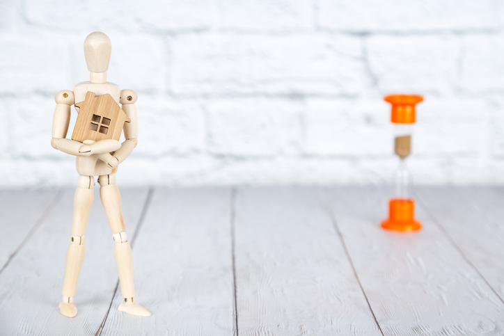 Wooden human puppet and hourglass beside