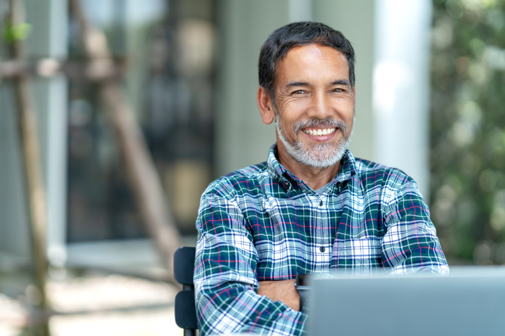 Portrait of happy mature man with white, grey stylish short beard looking at camera outdoor. Casual lifestyle of retired hispanic people or adult asian man smile with confident at coffee shop cafe.